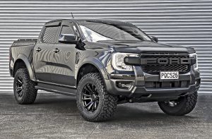 Black Ford Ranger on black multi-spoke alloy wheels with aggressive off-road tyres, front three-quarter view